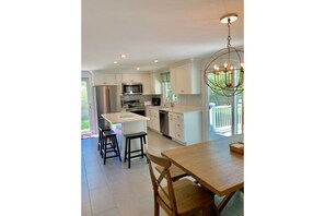 Recently renovated kitchen with quartz counters, 3 bar stools, ss applinaces
