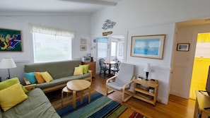 Open and bright living room with futon and TV