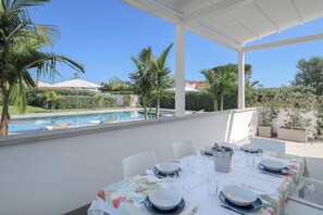Ampia zona living dove pranzare o cenare con vista giardino e piscina