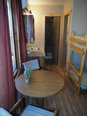 MAIN ROOM:  Features a small dining table with chairs, kitchenette  / sink, one twin-on-full bunk bed, and one twin-on-twin bunk bed.