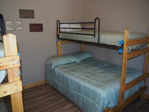 MAIN ROOM:  Features a small dining table with chairs, kitchenette  / sink, one twin-on-full bunk bed, and one twin-on-twin bunk bed.