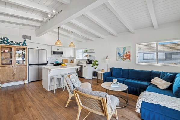 Living room/kitchen/dining open to balcony with ocean view over couch / balcony
