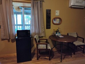 MAIN ROOM:  Features two double beds, small dining table with chairs, and a sink / kitchenette.