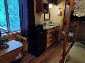 MAIN ROOM:  Includes two twin-on-twin bunk beds, a small dining table, chairs, and a kitchenette / sink.