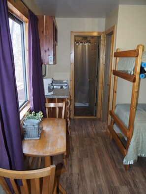 MAIN ROOM:  Includes two twin-on-twin bunk beds, a small dining table, chairs, and a kitchenette / sink.