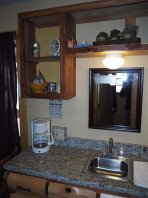 MAIN ROOM:  Includes two twin-on-twin bunk beds, a small dining table, chairs, and a kitchenette / sink.