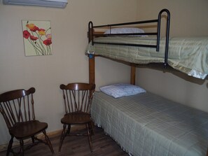 MAIN ROOM:  Includes two twin-on-twin bunk beds, a small dining table, chairs, and a kitchenette / sink.