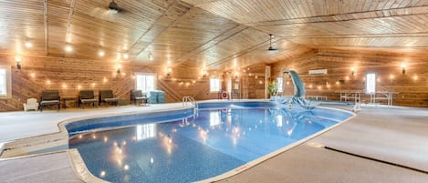The pool room includes a slide, hot tub, seating, ping pong, dining table & more