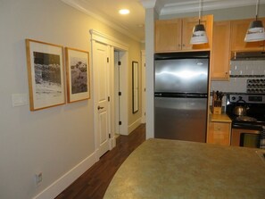 Hallway to bedroom and bathroom and stainless fridge.