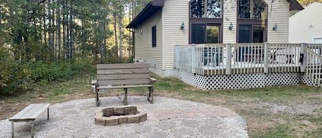 Exterior from front lawn, featuring fire pit and large deck