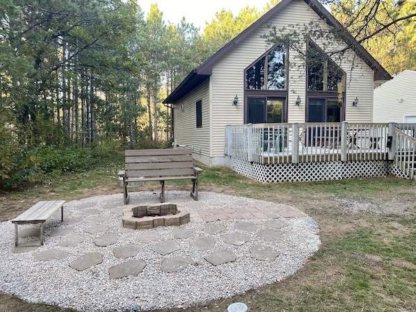 Exterior from front lawn, featuring fire pit and large deck
