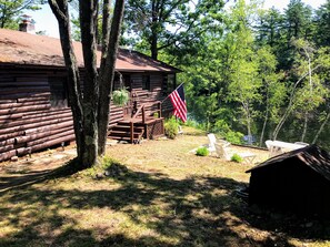 Entrance/side yard. Dock is to right of cabin.