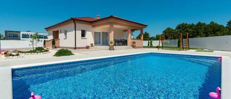 Heated pool on large patio with children`s play area