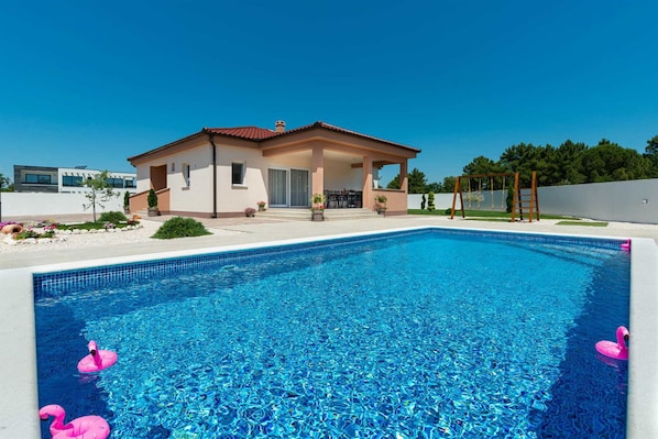 Heated pool on large patio with children`s play area