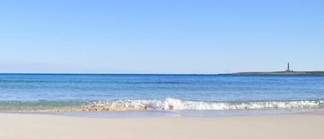 La baie de Punta  Prima, son eau turquoise et sable blanc. Au loin, l'ile d'Aire