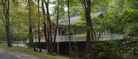 Front and side view house with wrap around deck.