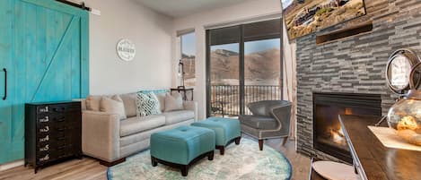 1364 Stillwater Dr #3067: Cozy sofa set by the fireplace, overlooking the serene balcony view.