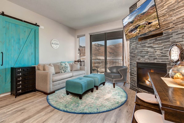 1364 Stillwater Dr #3067: Cozy sofa set by the fireplace, overlooking the serene balcony view.