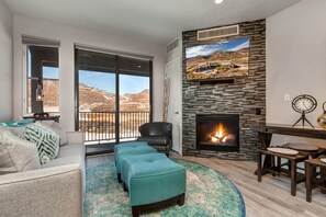 1364 Stillwater Dr #3067_06: Cozy sofa set by the fireplace, overlooking the serene balcony view.