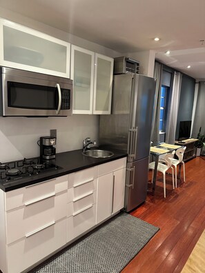 Kitchen with gas stove, microwave, full size refrigerator, dishes and cookware 