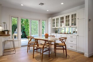 Saarinen marble table with seating for 6 and bar seating for two open to kitchen