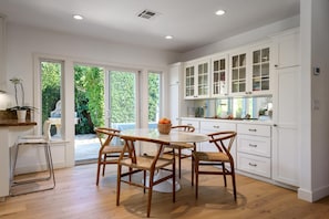 Saarinen marble table with seating for 6 and bar seating for two open to kitchen