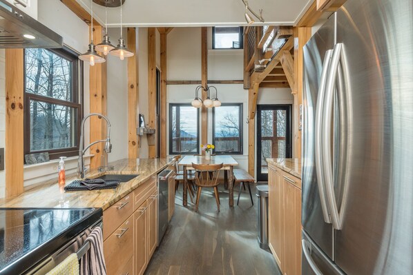 Sleek kitchen with stainless appliances, dishwasher, and farmhouse sink.