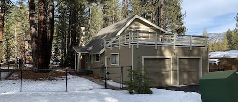 Street view of home. Self check-in with keyless entry. Wood deck above garage.