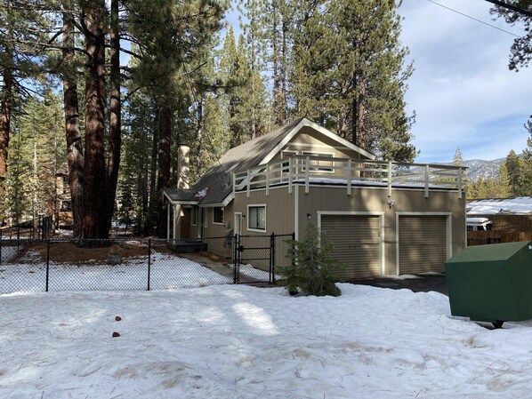 Street view of home. Self check-in with keyless entry. Wood deck above garage.