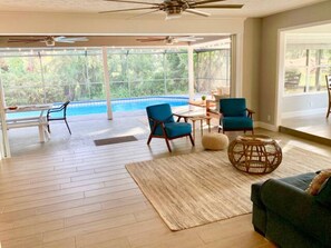 Sliding glass doors open fully to connect the living room and the patio
