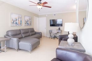 View of the fully furnished living room from the front door.  Includes leather furniture & 55" smart HDTV.