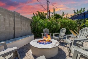 Gorgeous private backyard featuring a heated pool & spa, cabana, sun loungers, BBQ grill, outdoor dining, fire pit, cornhole and putting green.