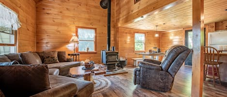 A comfy spacious living room with a woodstove- open concept to kitchen