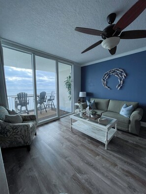 Living room with sofa bed, two sofa chairs and direct access to the balcony. 