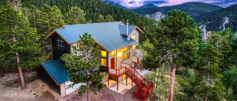 A cabin in the mountains at dusk.