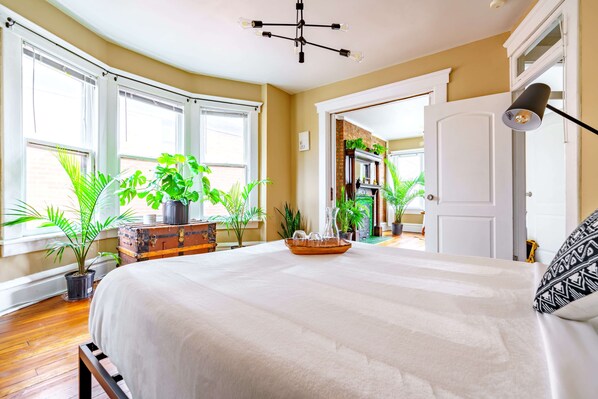 Deluxe bedroom offers a with a king size & queen-size bed and a mix of unique, artistic decor. The vibrant colors and diverse furnishings create a playful, creative atmosphere ~ Green Urban Haven in Ohio, Columbus