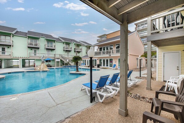 Relax on the patio with a picturesque view overlooking the sparkling pool—a perfect spot to unwind and enjoy the outdoors