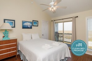 Master bedroom with full size bed, flat screen TV, and private balcony