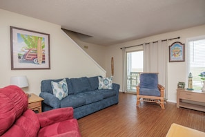 Coastal living area with cozy furnishings and private balcony