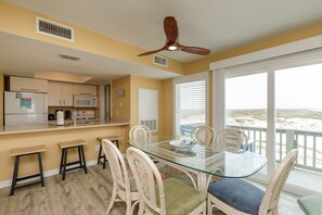 Open concept dining and kitchen area with seating for nine and a view of the water