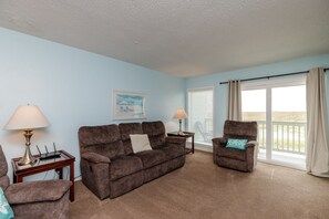 Living space with private balcony that has a view of the coastal dunes and the beach