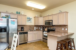 Fully equipped kitchen with plenty of storage and breakfast bar that seats three