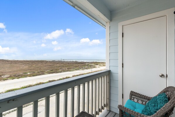 Step onto your private balcony off the master bedroom, where comfortable chairs await, offering peaceful views of the dunes just steps from the beach