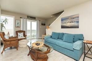 Living area with relaxed seating, private balcony and flat screen TV, includes a full size sleeper sofa and rollaway bed