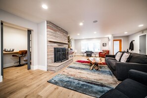 Living room with office space on the left and arcade space in the back.