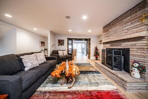 First living room with comfortable couches and decorative fireplace.