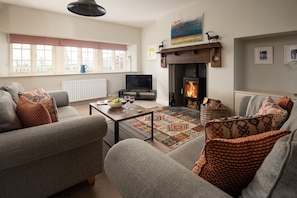 Farm Cottage - open-plan sitting room with fireplace and wood burner facing the front garden