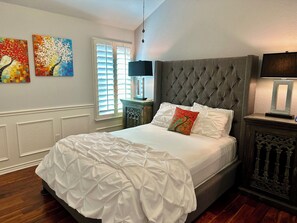 2nd bedroom with queen bed, ceiling fan and plantation shutters.