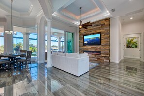 living room with tv and couch with views of the pool at canal