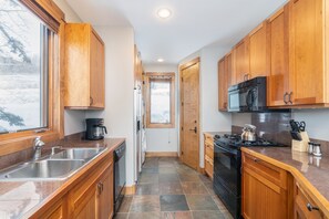 Kitchen with tile floor and black appliances